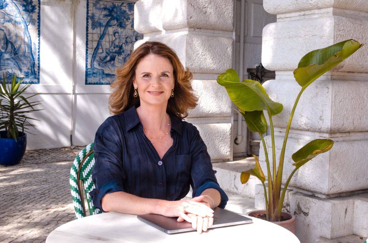 Beile Grünbaum ved et marmorbord udendørs foran azulejos